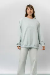 Buzo oversize de algodón frizado color beige, con cuello redondo, puños y cintura tejidos. Presenta un bordado tono sobre tono de Garfield en el frente.