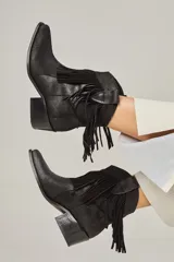 Botas texanas negras de cuero vacuno con flecos en la caña, punta fina y taco de 5.5 cm.