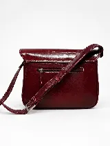 Cartera bandolera de cuero vacuno color bordó, con solapa frontal de textura símil cocodrilo y detalles de costuras pespunteadas en blanco. Cuenta con correa ajustable y cierre superior.