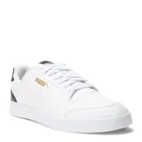 Championes Puma modelo Shuffle, de diseño urbano y silueta de corte bajo. Confeccionados en cuero sintético blanco con detalles en azul marino en el talón y logo de la marca en dorado. Presentan perforaciones en la puntera para mayor ventilación y cierre mediante cordones.