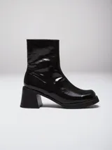 Bota de caña media confeccionada en cuero con acabado charol brillante. Presenta punta cuadrada, plataforma delantera y taco cuadrado robusto.
