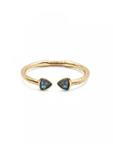 Pulsera rígida dorada de aleación de metales bañada en oro 18k, con dos cristales facetados multicolor en forma triangular en los extremos.