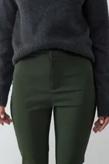 Pantalón recto cropped de tiro medio y fit slim color verde militar, confeccionado en tejido elástico, con cierre frontal oculto y sin bolsillos visibles.