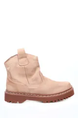 Botín de cuero en tono beige rosado, con diseño de caña baja y suela track de goma en color marrón. Presenta costuras decorativas visibles y una lengüeta en la parte superior trasera.