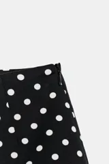 Shorts negros de tiro alto con estampado de lunares blancos, corte clásico y cierre lateral oculto.