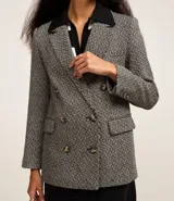 Blazer de tweed gris con diseño de espiga, doble botonadura, solapas de muesca, bolsillos cargo frontales y corte clásico.