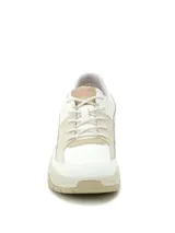 Sneaker Cat modelo Watchful, de diseño moderno en combinación de colores blanco y beige. Presenta capellada de cuero con detalles de costuras, cierre mediante cordones y suela de goma robusta con relieve.