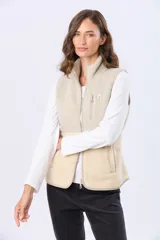 Chaleco de sherpa combinado en tonos beige, con cuello alto y cierre frontal. Presenta una textura suave y abrigada, ideal para capas adicionales.
