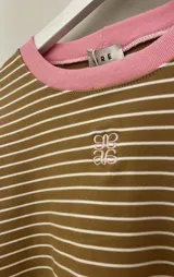 Pijama set de dos piezas compuesto por una remera de manga larga a rayas horizontales con cuello redondo celeste, y un pantalón largo de corte holgado a rayas verticales con cordón de ajuste en la cintura.