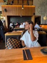 Bolso tipo tote de cuero trenzado a mano con diseño de damero en colores marrón y beige. Cuenta con doble asa trenzada y forro interior.