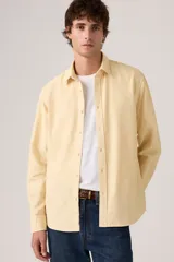 Camisa de manga larga color amarillo claro con cierre frontal de botones, cuello camisero y calce clásico.