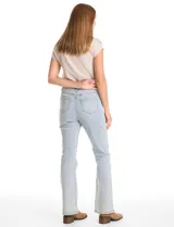 Jean de tiro alto con corte bootcut, confeccionado en denim de lavado claro. Presenta cierre frontal con botón, bolsillos funcionales y detalle de pespuntes verticales con aplicación de tachas a lo largo de las piernas.