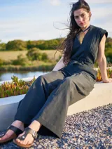 Mono color arena de lino, con cuello mao, cierre frontal con cremallera, mangas cortas y cinturón de lazo.