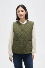 Chaleco acolchado color verde militar, con diseño matelasseado, cierre frontal con botones a presión y dos bolsillos delanteros aplicados.