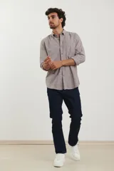 Camisa de manga larga con cuello abotonado, cierre frontal con botones y bolsillo en el pecho. Presenta un diseño de textura melange en tono azul piedra.