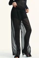 Pantalón negro de tiro alto con cintura elástica y pierna recta. Confeccionado en tela semitransparente, con forro corto interior a tono.