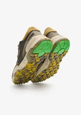 Championes urbanos Satorisan modelo Chacrona, confeccionados en cuero marrón con detalles en gamuza, cordones amarillos y suela de goma con efecto salpicado y detalles en verde.