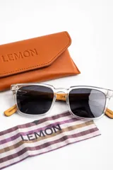 Lentes de sol polarizados con armazón transparente y patillas de madera, con cristales oscuros.