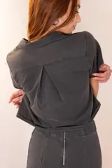 Top de manga corta color gris oscuro con cuello tipo solapa y cierre frontal de botones.