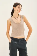 Top sin mangas de tejido de punto compacto con escote en U pronunciado. Presenta una textura sedosa y brillante, con un diseño ajustado al cuerpo.