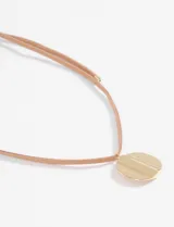 Collar de cordón fino en tono natural con un dije metálico circular de acabado brillante y diseño texturizado.