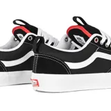 Championes de skate Vans modelo Old Skool 36+, color negro con franja lateral (sidestripe) blanca y costuras blancas. Suela de goma blanca gruesa y cordones blancos. Presenta detalles en rojo en el talón.