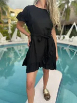 Vestido corto blanco de lino con corte evasé, mangas cortas con volados y cinto del mismo material.