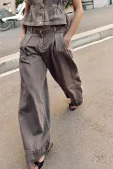 Jeans de tiro medio con corte wide leg y pernera ancha. Presenta pinzas delanteras, bolsillos frontales, bolsillos de plastrón en la espalda y cierre frontal con cremallera, botón interior y ganchos metálicos.