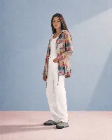 Campera impermeable con capucha y cordón ajustable, con diseño estampado a cuadros multicolor y hojas grandes. Cuenta con cierre frontal de botones y bolsillos laterales.