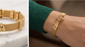 Pulsera de acero italiano con baño de oro, diseño de malla metálica con dijes colgantes del Árbol de la Vida y la palabra 'life', decorada con barras de circonias.