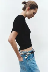 Jersey de punto fino con cuello redondo y manga corta, con terminaciones en rib en cuello, mangas y ruedo.