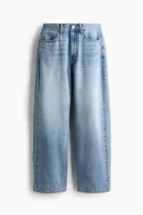 Jean de cinco bolsillos en denim de algodón rígido, de diseño curvo con volumen y corte holgado de cadera a muslo, algo más ceñidas en el bajo. Cintura clásica con cierre y botón.