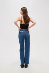 Pantalon de jean negro de corte recto y tiro alto, con detalle de tachas metálicas en la cintura.