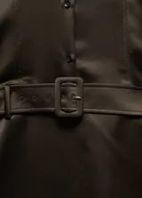 Vestido corto de satén color marrón oscuro, con cuello camisero, cierre frontal de botones y mangas largas con puños abotonados. Incluye un cinturón desmontable con hebilla a tono y cierre lateral con cremallera invisible.