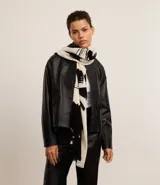 Bufanda confeccionada en franela de acrílico con flecos y estampa de follajes en blanco y negro.