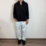 Camisa de manga larga confeccionada en lino, color blanco, con cuello clásico y cierre frontal de botones.