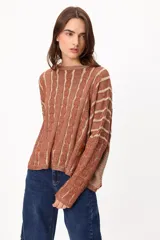 Sweater de punto con diseño de rayas verticales en relieve y textura trenzada, color terracota y beige. Presenta cuello redondo, corte holgado y diseño cropped.