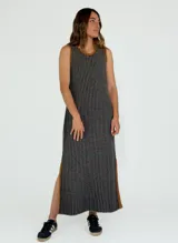 Vestido midi de punto con diseño a rayas verticales en tonos mostaza y blanco, con cuello redondo y sisas contrastadas en color bordó. Presenta aberturas laterales en el ruedo con detalles en color bordó.