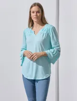 Blusa color celeste con escote en V, mangas largas acampanadas con detalle de crochet y frunces en los hombros.