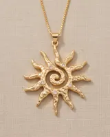 Collar de bronce con baño de oro, compuesto por una cadena fina y un dije colgante en forma de sol con textura irregular y detalles de circonitas incrustadas.