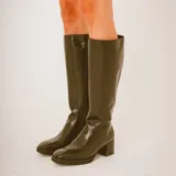 Botas altas de cuero color negro con diseño texturizado estilo animal print tipo cocodrilo en la parte frontal y trasera, taco cuadrado y puntera cuadrada.