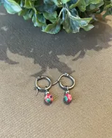 Aros de argolla de acero con dije redondo de fimo con diseño floral multicolor y bolita de acero en la terminación.