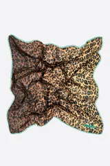 Chal cuadrado con estampado animal print y efecto degradado de marrón a amarillo. Presenta bordes con flecos cortos en color verde contraste y etiqueta de la marca en una esquina.