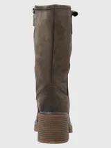 Bota de caña media confeccionada en cuero descarne, con diseño de costuras visibles y taco cuadrado de altura media. Presenta una suela con plataforma y un detalle de tira con hebilla en la parte superior de la caña.