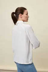 Camisa negra de calce relajado, con mangas 3/4, cuello clásico y cierre frontal con botones. Presenta detalles calados en la parte superior.