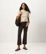 Blusa de ribana color marrón con rayas horizontales blancas, cuello medio, mangas cortas y corte ajustado.