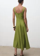 Vestido midi evasé color verde, sin mangas, con tirantes anchos, cuello escotado y costuras decorativas. Cuenta con forro interior y cierre de cremallera en la parte posterior.