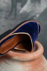 Sandalias de terciopelo azul marino con ribete dorado y plantilla de cuero tostado, de diseño abierto en la punta.