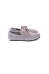 Mocasín de cuero gamuzado color gris, con lazo frontal y detalle de pasacintas laterales. Cuenta con suela flexible antideslizante.