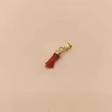 Dije de oro amarillo 18k con forma de mano y coral rojo.